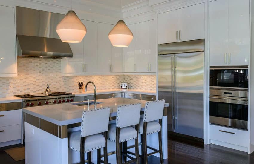 Kitchen with transitional design, high gloss white cabinets, penant lighting and quartz counter island