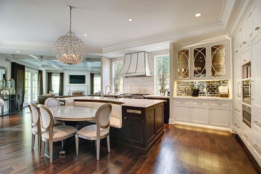 Kitchen with white flat panel cabinets and large island with built in seating bench