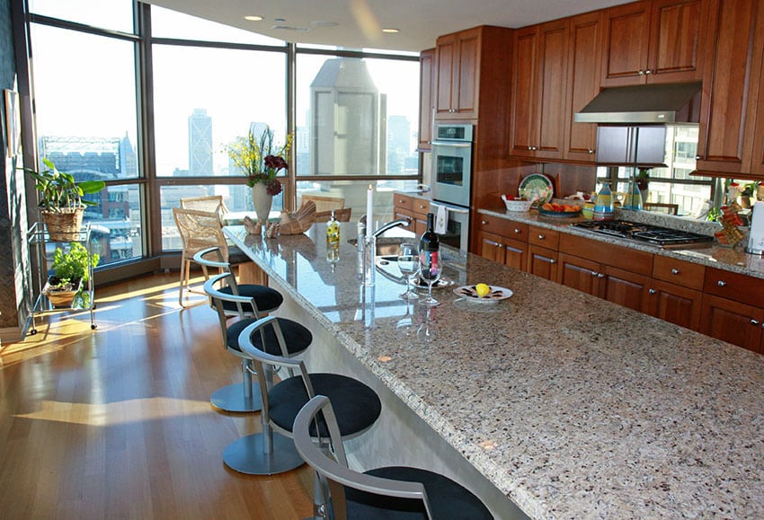 Large kitchen island with light granite counter and modern seating