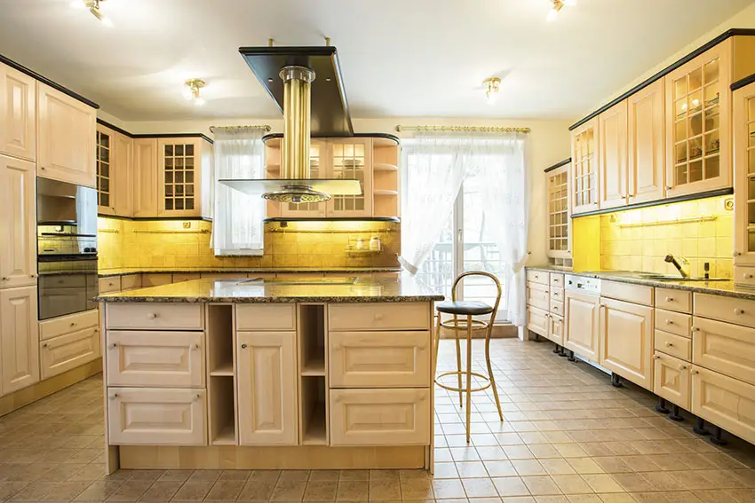 Large kitchen with under cabinet lighting and small tiles as flooring