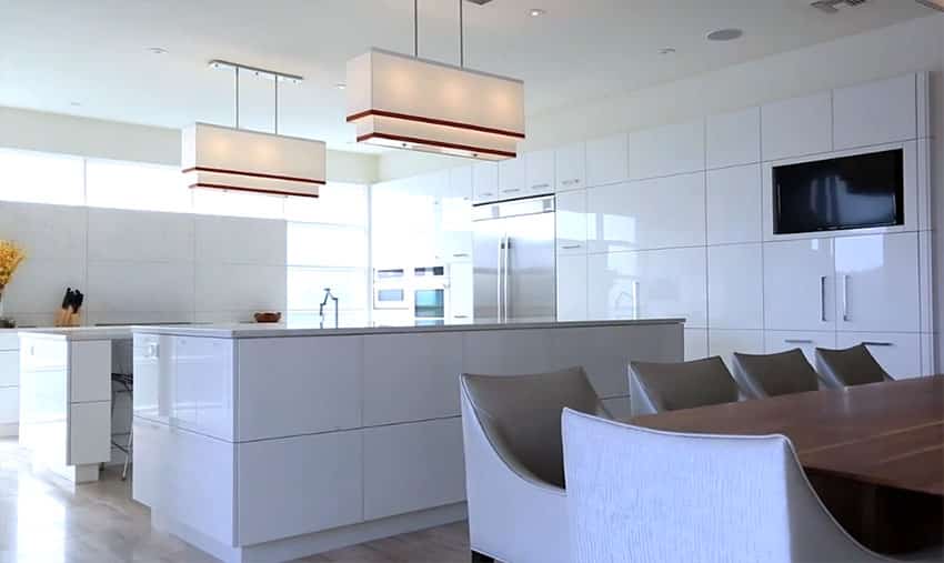 Large open concept white modern kitchen with high gloss cabinets and two islands