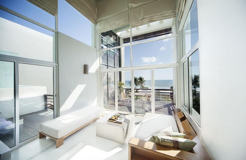Living room with ocean view and high ceiling with door to outdoor patio