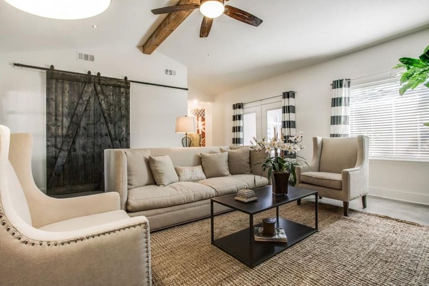 Room with white shutters, wooden ceiling fan and black center table 