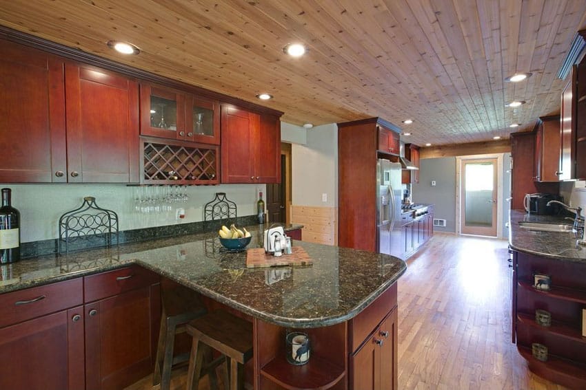 Long galley kitchen with small peninsula and ubatuba granite countertop