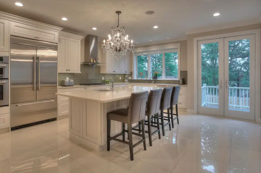 Cream-toned kitchen with stainless stell appliances and large-cut porcelain floor tiles