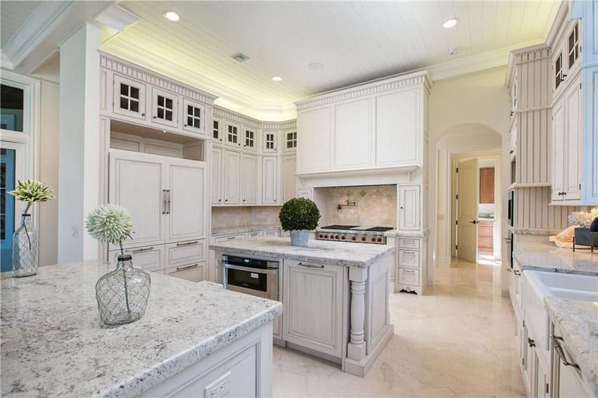 Luxury country kitchen with white cabinets and white venatino marble countertops with island and peninsula