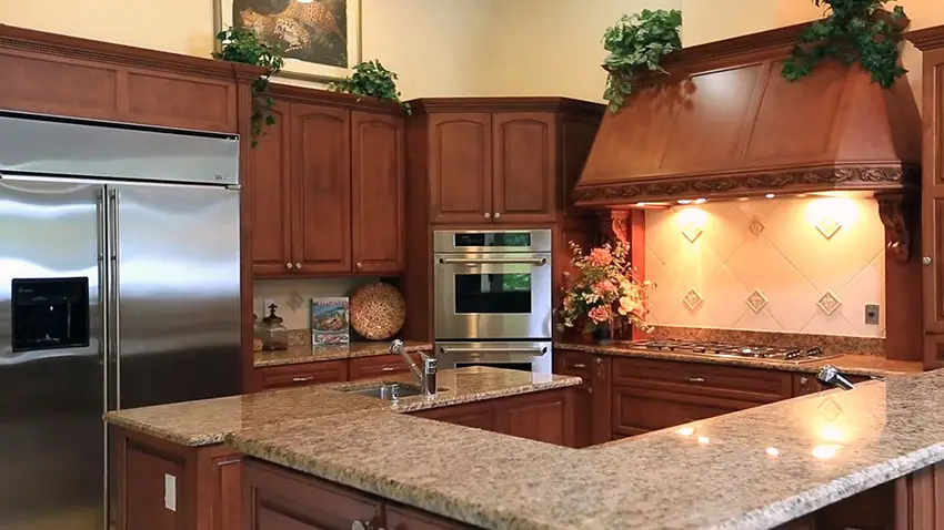 Luxury kitchen with custom exhaust hood and brown granite countertops