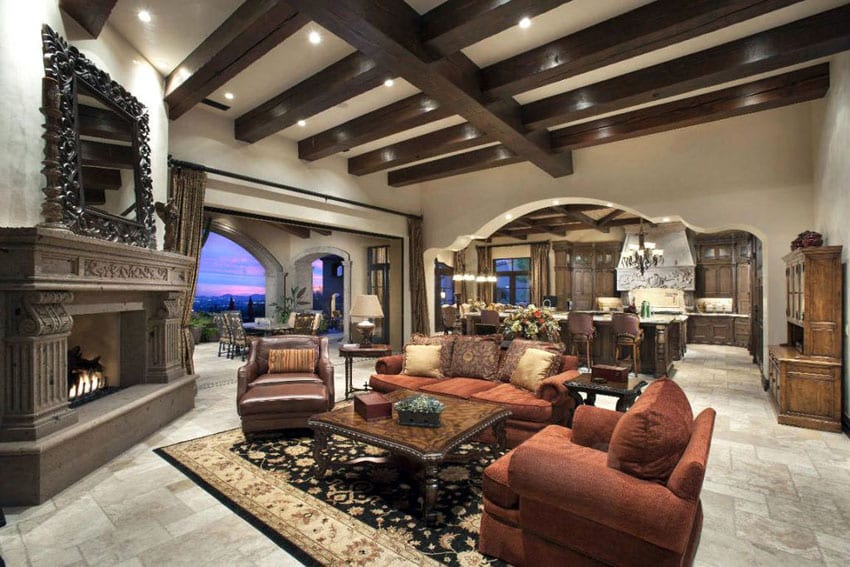 Luxury Mediterranean living room with cement fireplace, wood beam ceiling and honed travertine floors