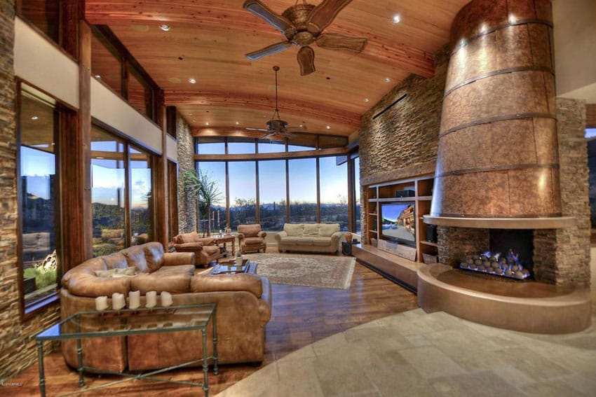 Luxury rustic living room with brown leather furniture and curved ceiling custom copper fireplace