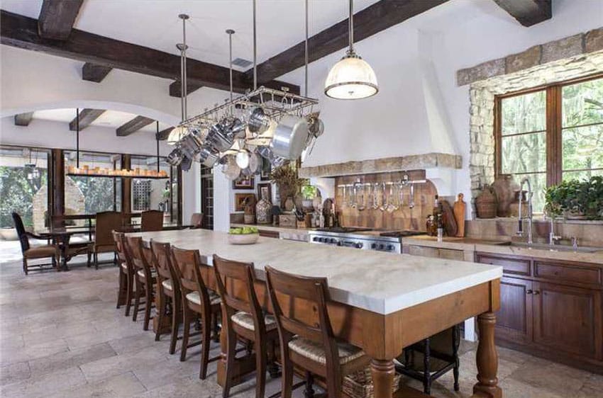 Mediterranean style kitchen with long seating island with marble counter