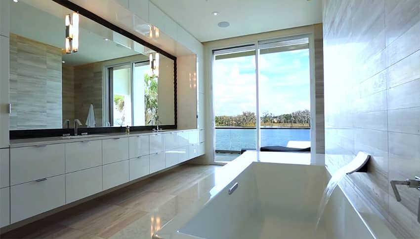 Modern bathroom with white gloss cabinets and lake views