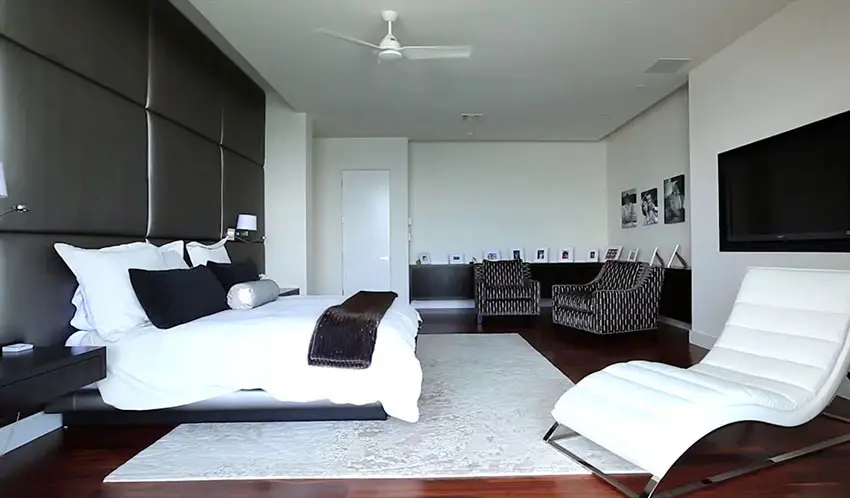 Modern bedroom with padded black accent wall and black decor