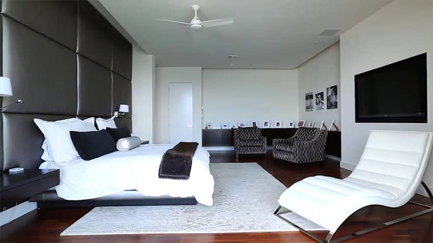Modern black and white bedroom design with wall sized leather headboard