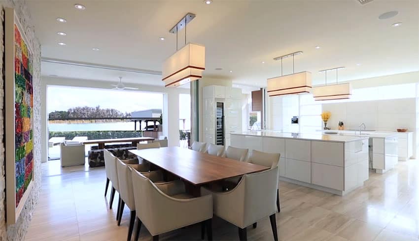 Modern dining room with lake views open to white gloss cabinet kitchen