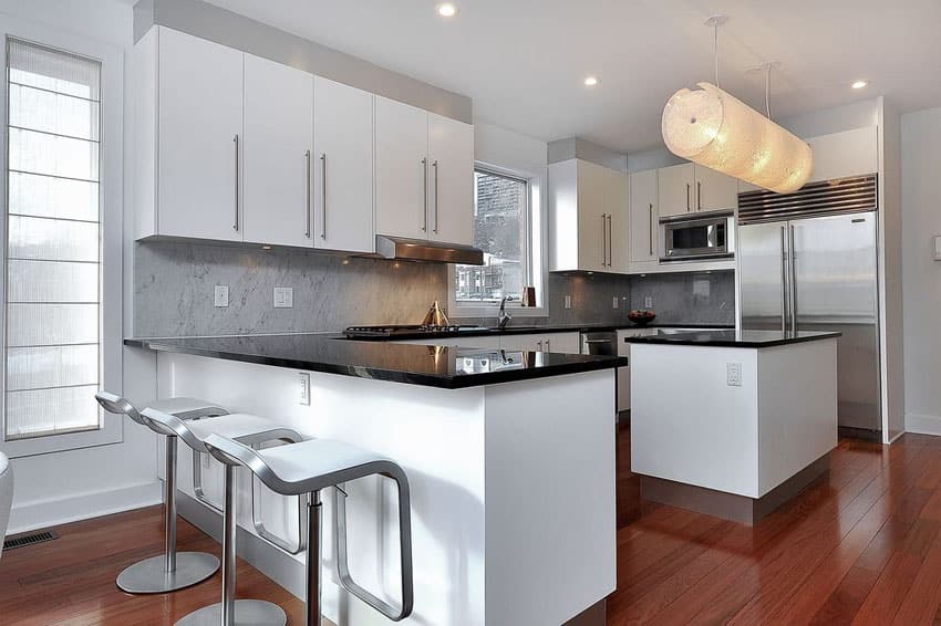 Modern kitchen with black counters and hardwood flooring