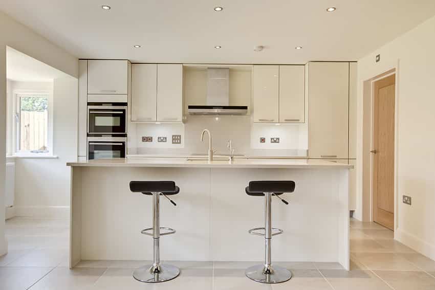 Kitchen with cream cabinets with chrome hardware and stools