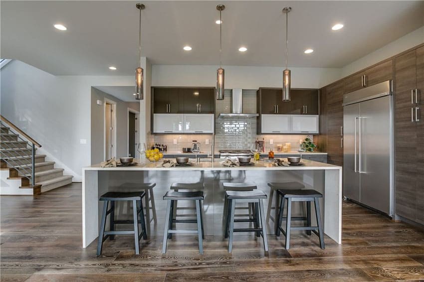 Modern kitchen with large island with dining stools and brown laminate cabinets