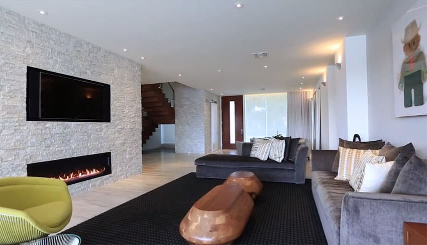 Modern living room with stacked stone fireplace wall with casual furniture