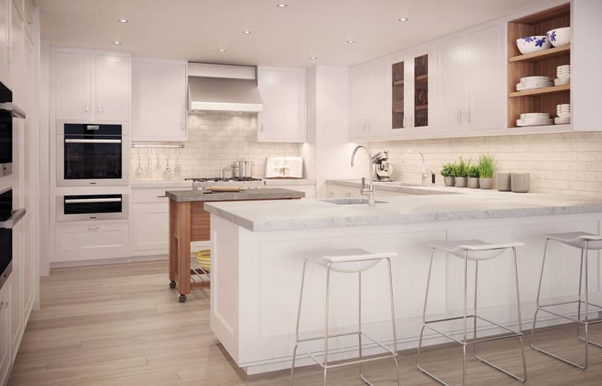 Modern white kitchen with marble counter peninsula and portable rolling island