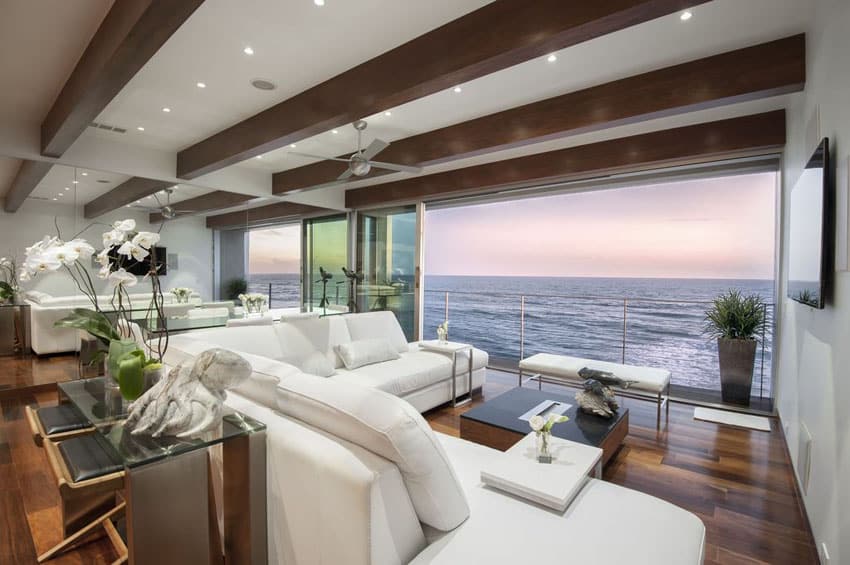 Ocean view contemporary living room with sliding glass doors wood flooring and beam ceiling