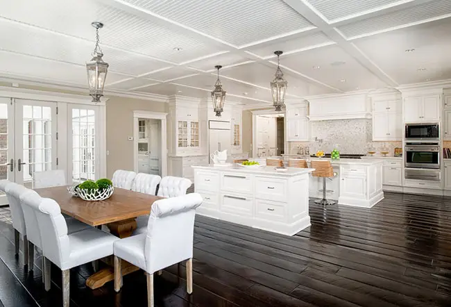 White dining chairs and lantern pendant lights