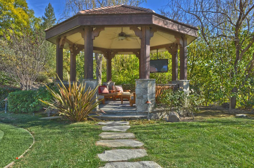 pathway leading to large gazebo with outdoor lounge furniture