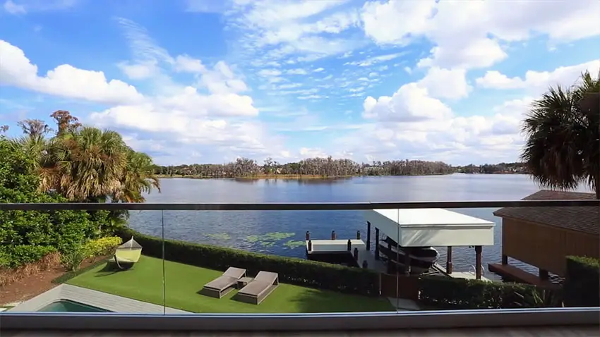 Second story balcony view of lake with glass railing