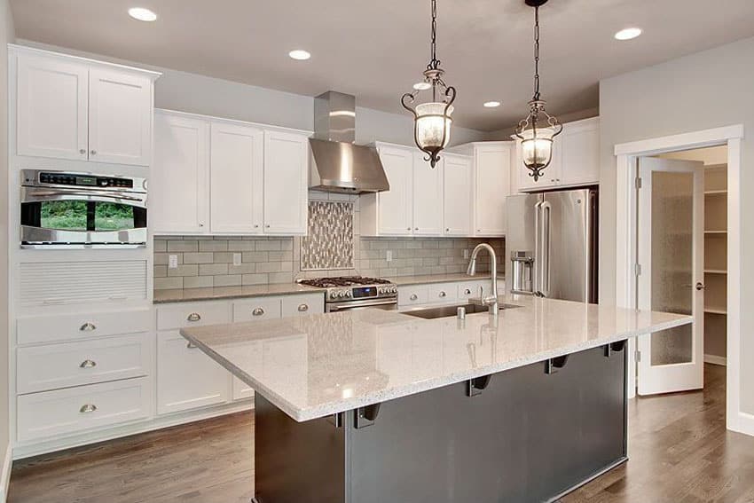Contemporary kitchen with white cabinets and gray island with quartz countertops