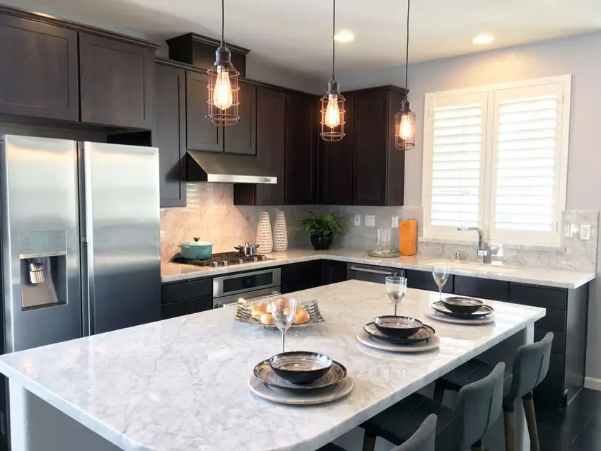 Small contemporary kitchen with calacatta carrara marble counter dark cabinets and edison lights
