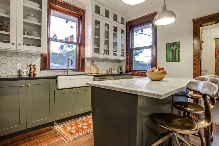 Small cottage kitchen with green cabinetry island, glass faced cabinets and farmhouse sink