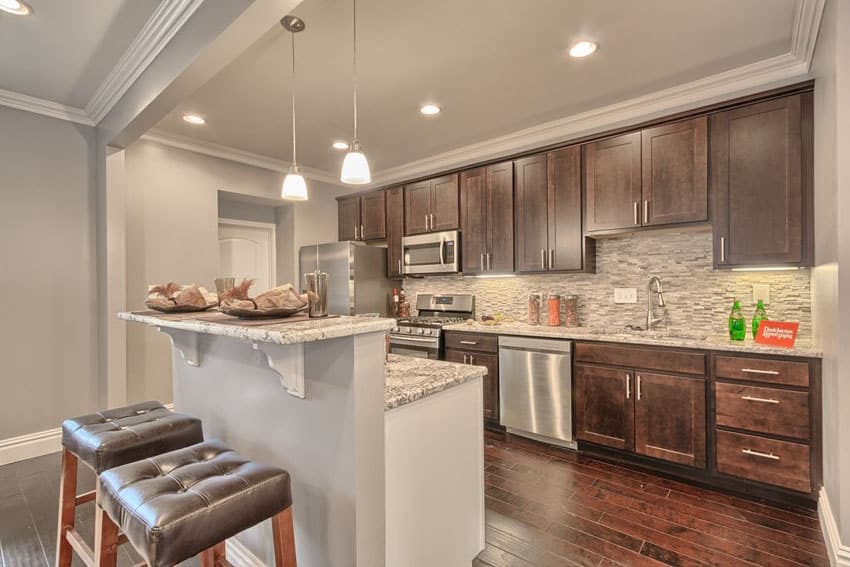Small transitional kitchen with moon white granite counter and breakfast bar