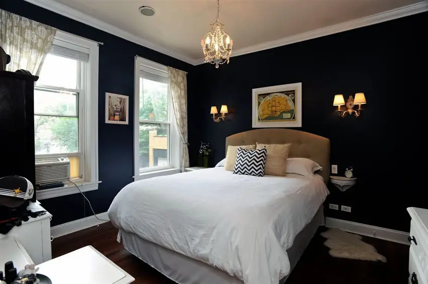Traditional bedroom with dark walls, white molding and mini chandelier