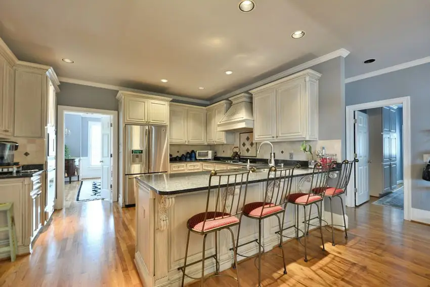 Kitchen with breakfast peninsula and four bar chairs with uphostered seating