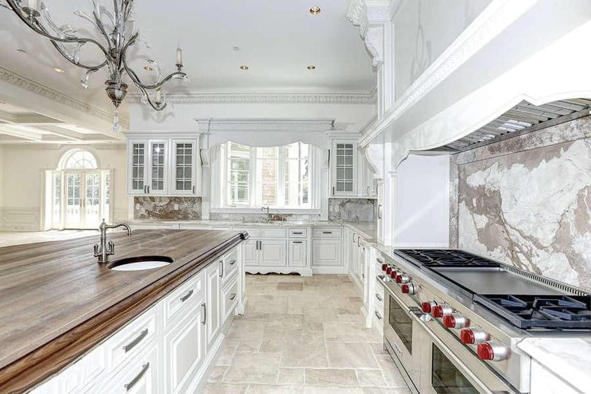 Traditional kitchen with butcher block wood island, decorative molding and marble backsplash