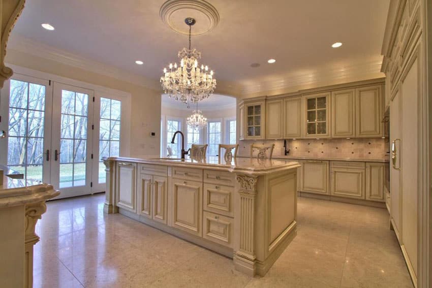 Traditional kitchen with cream cabinets, chandelier and crema marfil marble counter
