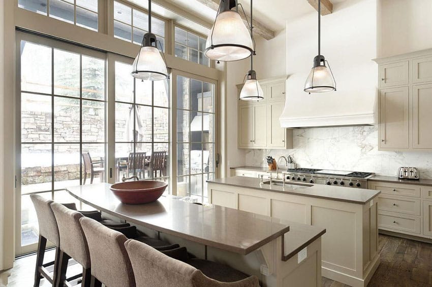 Narrow island and bar made of light taupe granite and white range hood