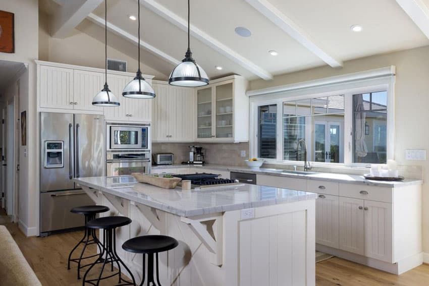 Kitchen with carrara white marble breakfast bar and beadboard cabinets