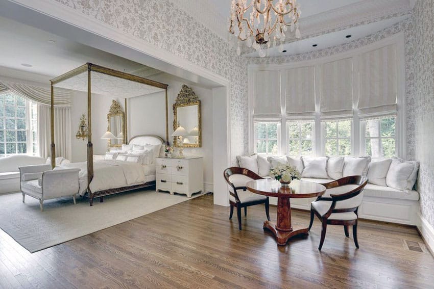 Traditional master bedroom with Georgian four poster bed chandelier and window seat sofa