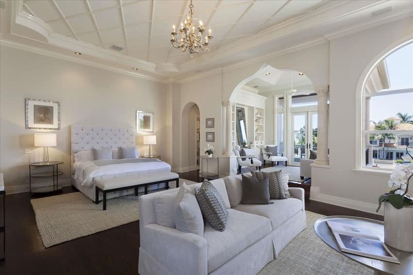 Traditional master bedroom with white fabric bed, sofa seat and chandelier
