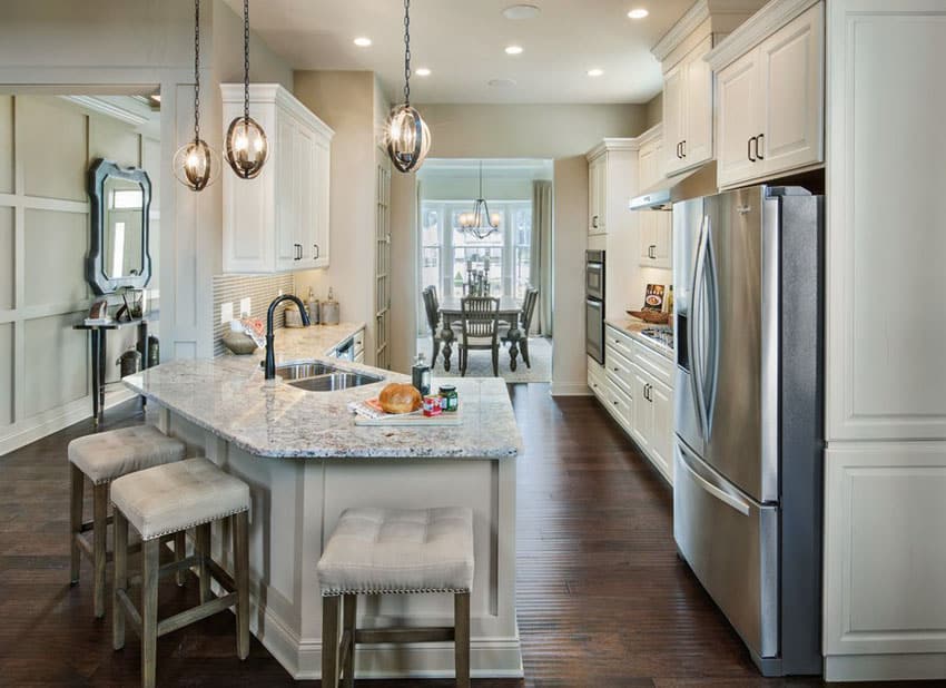 Traditional white kitchen with angled peninsula and cushioned bar stools