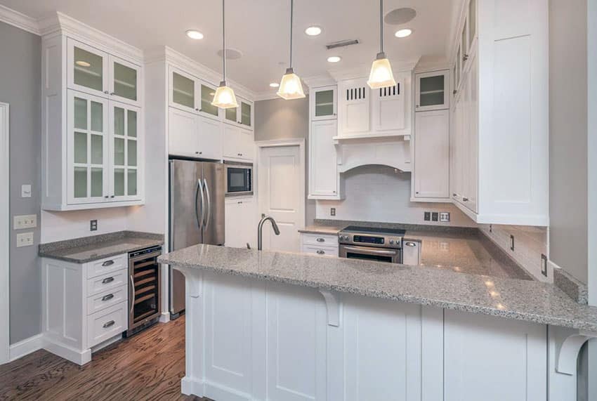 Traditional white cabinet kitchen with peninsula, granite counters and pendant lighting