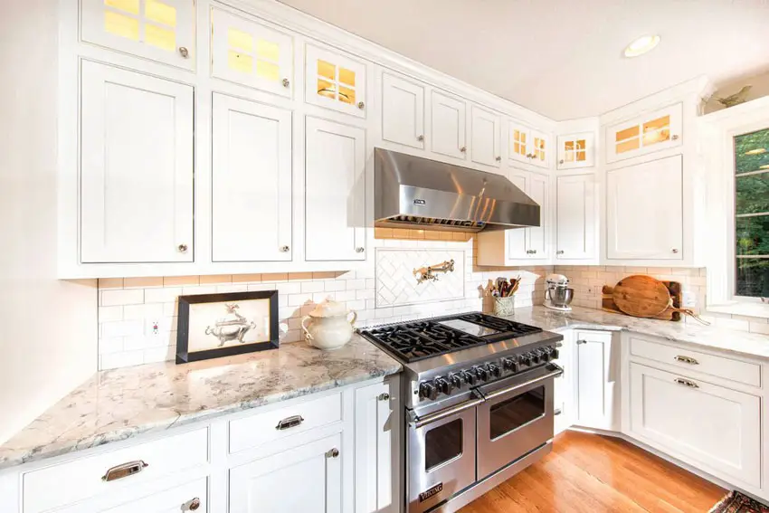 Traditional white cabinet kitchen with white granite, subway tile backsplash, and oak engineered hardwood flooring