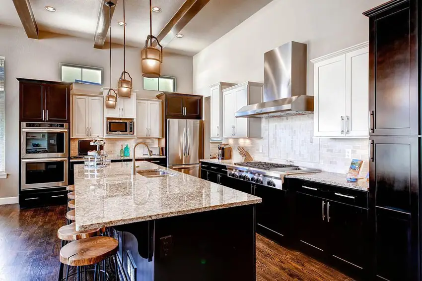 Transitional kitchen design with african rainbow granite counters, dark shaker cabinets and mini pendant lights