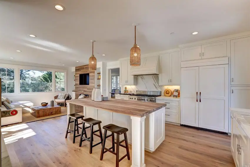 Transitional kitchen with calacatta white marble counters, butcher block island and wide plank hardwood flooring