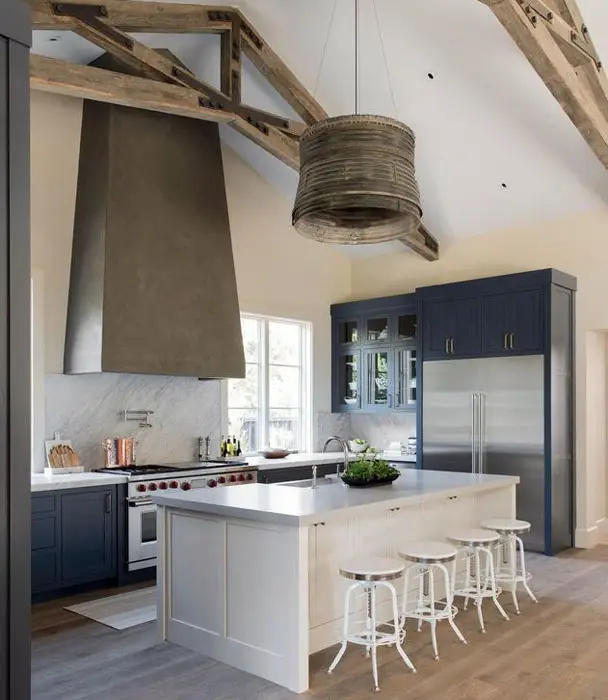 Transitional kitchen with dark blue cabinets and white island with white bar stools