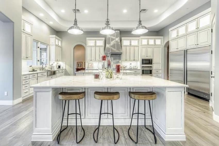 Transitional kitchen with white cabinets and wood grain porcelain tile floors and industrial style pendant lights