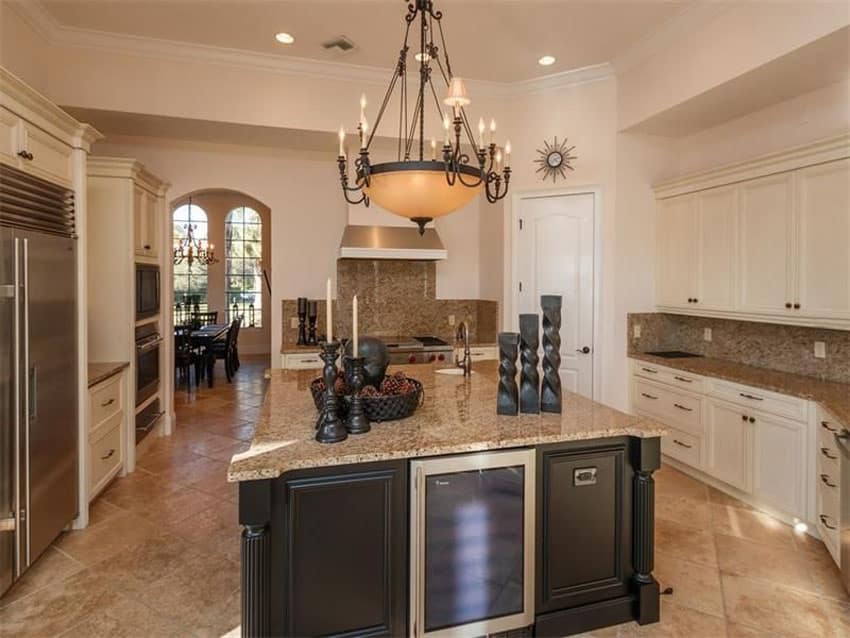 U shaped kitchen with cream cabinets and dark wood island with beige granite counters