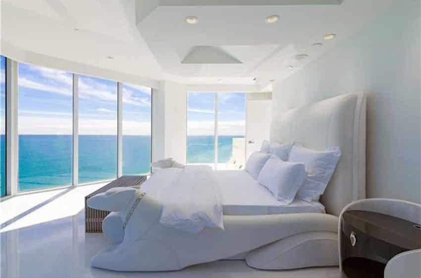 White bedroom with ocean views and custom bed frame