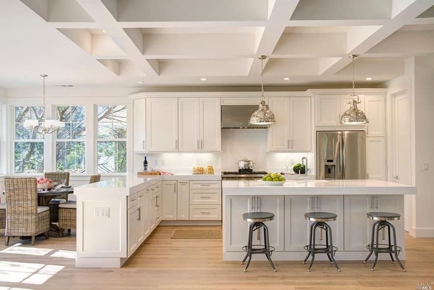 White cabinet transitional kitchen with arctic white quartz countertops, peninsula breakfast bar island and dining nook