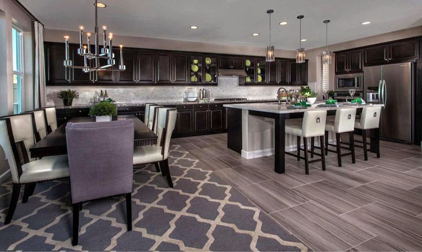 Kitchen with candle style chandelier. white peninsula and wood grain pocelain tile floor